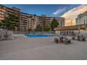 Community pool, with lounge chairs, tables, and seating areas, adjacent to the building at 205 E Harmon Ave # 1007, Las Vegas, NV 89169