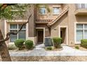 Close-up of townhouse exterior featuring a stone accent, walkway, and efficient air conditioning at 2787 Fountain Ridge Ln, Henderson, NV 89074
