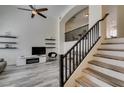 Bright living room featuring modern staircase, sleek ceiling fan, and floating display shelves at 2787 Fountain Ridge Ln, Henderson, NV 89074