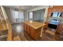Open kitchen with stainless steel appliances, large island, and hardwood flooring at 3938 E Chaffe Ave, Pahrump, NV 89061