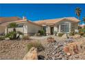 Attractive one-story home with desert landscaping featuring rocks, stones, and mature palm trees at 3961 Equinox Ct, Las Vegas, NV 89147