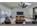 Staged living room with vaulted ceiling, modern ceiling fan, fireplace, and neutral decor at 5151 Tennis Ct, Las Vegas, NV 89120