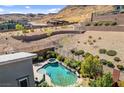 An aerial perspective showcases the stunning pool, spa, and terraced landscaping against a desert mountain backdrop at 6491 Wild Blue Ct, Las Vegas, NV 89135
