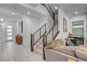 Bright, modern living room with wood floors, staircase and designer touches, creating a welcoming space at 6491 Wild Blue Ct, Las Vegas, NV 89135