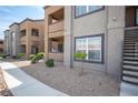 Apartment building exterior with neutral colors, small bushes, and a sidewalk at 6650 W Warm Springs Rd # 1079, Las Vegas, NV 89118