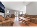 Spacious living room featuring wood floors, fireplace, neutral walls, and access to the backyard at 1010 Armillaria St, Henderson, NV 89011