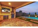 Inviting backyard with a covered patio, outdoor kitchen, and refreshing pool at 154 Nine Mile Creek Dr, Las Vegas, NV 89138