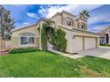 Lovely home with lush green lawn, mature landscaping, and a two-car garage, creating curb appeal at 2073 Sapphire Valley Ave, Henderson, NV 89074
