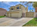 Charming home featuring a manicured lawn, mature trees, and a convenient two-car garage and gated driveway at 2073 Sapphire Valley Ave, Henderson, NV 89074