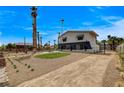 Spacious driveway and front yard with desert landscaping, palm trees, and gated entry at 2685 S Tenaya Way, Las Vegas, NV 89117