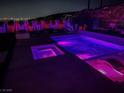 Backyard pool and spa area featuring lounge chairs and manicured landscaping with outdoor lighting at 270 Shaded Canyon Dr, Henderson, NV 89012
