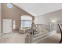 Open-concept living room featuring high ceilings, neutral carpet, white stairway railing, and sectional sofa at 2716 Timber Crossing Ct, Henderson, NV 89074