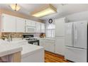 Bright kitchen featuring white cabinets, stainless steel refrigerator, and tile countertops at 3125 N Buffalo Dr # 1091, Las Vegas, NV 89128