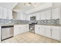 A well-lit kitchen featuring white cabinets, stainless steel appliances, and a modern backsplash at 3371 Royce Ct, Las Vegas, NV 89121