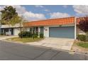 Charming single story home with orange tile roof, blue garage door, and well maintained front yard at 3871 Sinclair St, Las Vegas, NV 89121