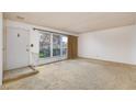 A spacious living room with a large window and neutral carpet, awaiting personal touches at 3871 Sinclair St, Las Vegas, NV 89121