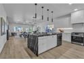 Open concept kitchen with stainless appliances and a black marble island open to living area at 4434 Verdiccio Ave, Las Vegas, NV 89141
