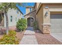 Inviting front entrance with stone accents, landscaping, and a paved walkway leading to the front door at 7154 Brighton Village St, Las Vegas, NV 89166