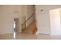 Home entryway featuring tile floors, staircase with wood trim and a chandelier at 7720 Leavorite Dr, Las Vegas, NV 89128