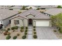 An elevated view of a well-maintained, single-story home with a tile roof, desert landscaping, and a two-car garage at 8393 Canyon Crevasse St, Las Vegas, NV 89166