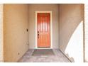 Close-up of the orange front door with a welcoming entryway and neutral stucco walls at 8393 Canyon Crevasse St, Las Vegas, NV 89166