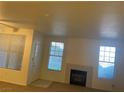 Bright living room featuring a decorative fireplace, two large windows, and ample natural light at 8555 W Russell Rd # 1078, Las Vegas, NV 89113