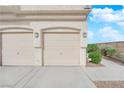 Townhouse featuring attached 2 car garage with traditional doors and exterior lantern lighting at 9315 Indian Corn Ct # 101, Las Vegas, NV 89178