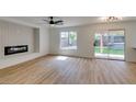 Spacious living room with modern fireplace, ceiling fan, and sliding glass doors to backyard at 9855 Ashton Pines Ct, Las Vegas, NV 89147
