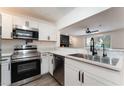 Modern kitchen featuring stainless steel appliances, white cabinets and granite countertops with a stainless steel sink at 1408 E Carson Ave, Las Vegas, NV 89101