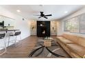 Bright living room with fireplace, ceiling fan, modern decor and wood floors and access to the kitchen at 1408 E Carson Ave, Las Vegas, NV 89101