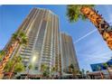 Exterior angle shot of luxury high-rise buildings with palm trees and a view of the clear blue sky at 145 E Harmon Ave # 201, Las Vegas, NV 89109