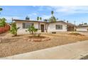 Inviting single-story home with rock landscaping, mature trees, and charming curb appeal at 2021 N Michael Way, Las Vegas, NV 89108