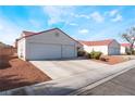 Side angle shot of a single story home, showing two car garage, and xeriscaped yard at 2117 Mountain Sunset Ave, North Las Vegas, NV 89031