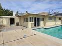 Backyard with a covered patio area, a swimming pool, and views of the surrounding landscape at 2501 Capistrano Ave, Las Vegas, NV 89121
