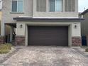 Attached two-car garage with brick driveway and well-maintained landscaping for curb appeal at 2674 Duneville St, Las Vegas, NV 89146