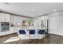 Modern kitchen features white cabinets, stainless steel appliances, granite countertops, and a large island at 5662 Escamilla Rd, Las Vegas, NV 89135