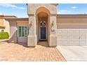 Home featuring an arched entryway and a beautiful brick walkway to the front door at 5752 Shermer Ct, Las Vegas, NV 89120