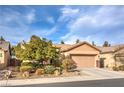 Charming single-story home with a well-maintained front yard, a two car garage and a desert landscaped yard at 6128 Forest Pony Ave, Las Vegas, NV 89122