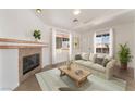 Cozy living room featuring a fireplace, neutral sofa, and bright windows at 6808 Elm Creek Dr # 203, Las Vegas, NV 89108
