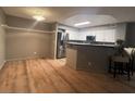 Open-concept kitchen featuring white cabinets, stainless steel appliances, and a breakfast bar with seating at 7904 Greycrest Ct # 104, Las Vegas, NV 89145