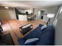 Comfortable living room showcasing hardwood floors, a navy sofa, and a coffee table, creating a relaxing ambiance at 7904 Greycrest Ct # 104, Las Vegas, NV 89145