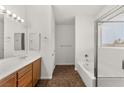 Clean bathroom with dual sinks, wood cabinets, and a separate tub and shower at 820 Wintersweet Rd, Henderson, NV 89015