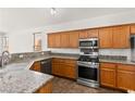Well-lit kitchen featuring stainless steel appliances, granite countertops, and oak cabinetry at 820 Wintersweet Rd, Henderson, NV 89015