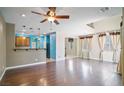 Open-concept living room with hardwood floors, ceiling fan, and kitchen access at 8261 Peaceful Mountain Ave, Las Vegas, NV 89178