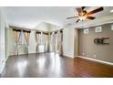 Bright, open living room with ample windows, hardwood floors, and modern ceiling fan at 8261 Peaceful Mountain Ave, Las Vegas, NV 89178