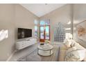 Bright living room featuring vaulted ceilings, modern decor, and a walk-out to backyard at 8470 S Pioneer Way, Las Vegas, NV 89113