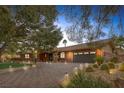 Well-maintained brick home showcasing desert landscaping and brick-paved driveway at 9 Quail Run Rd, Henderson, NV 89014