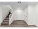 Bright entryway with laminate flooring, a white front door, and stairs leading to the upper level at 9006 Cedar Door Ave, Las Vegas, NV 89148