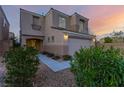 Stylish two-story home with neutral stucco, a two-car garage, and manicured landscaping at 9006 Cedar Door Ave, Las Vegas, NV 89148
