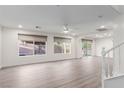 Open living area with laminate floors, modern ceiling fan, and large windows providing natural light at 9006 Cedar Door Ave, Las Vegas, NV 89148